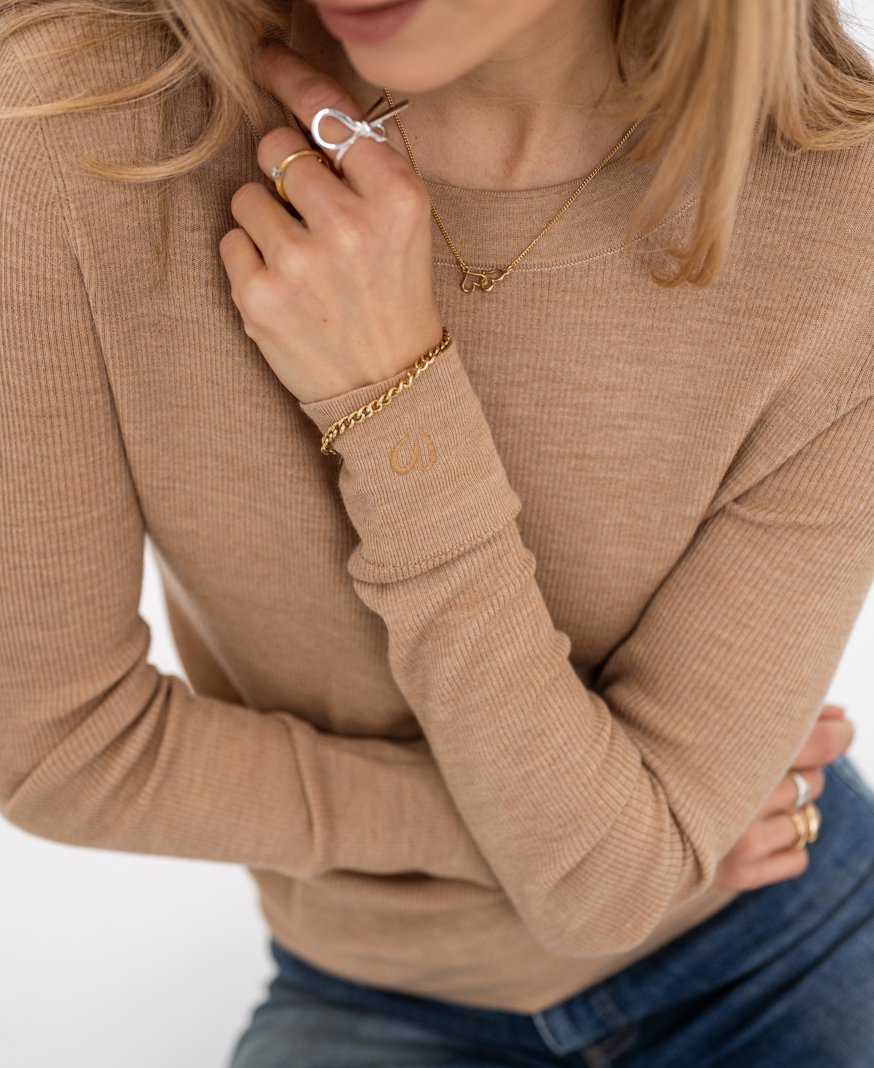 Woman wearing PLEIN PUBLIQUE's slim-fit camel Merino wool shirt, LA MEGEVE.