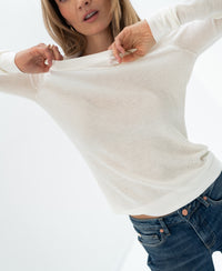 Ivory merino wool undershirt in a luxe style, shown being lifted slightly against a bright backdrop.