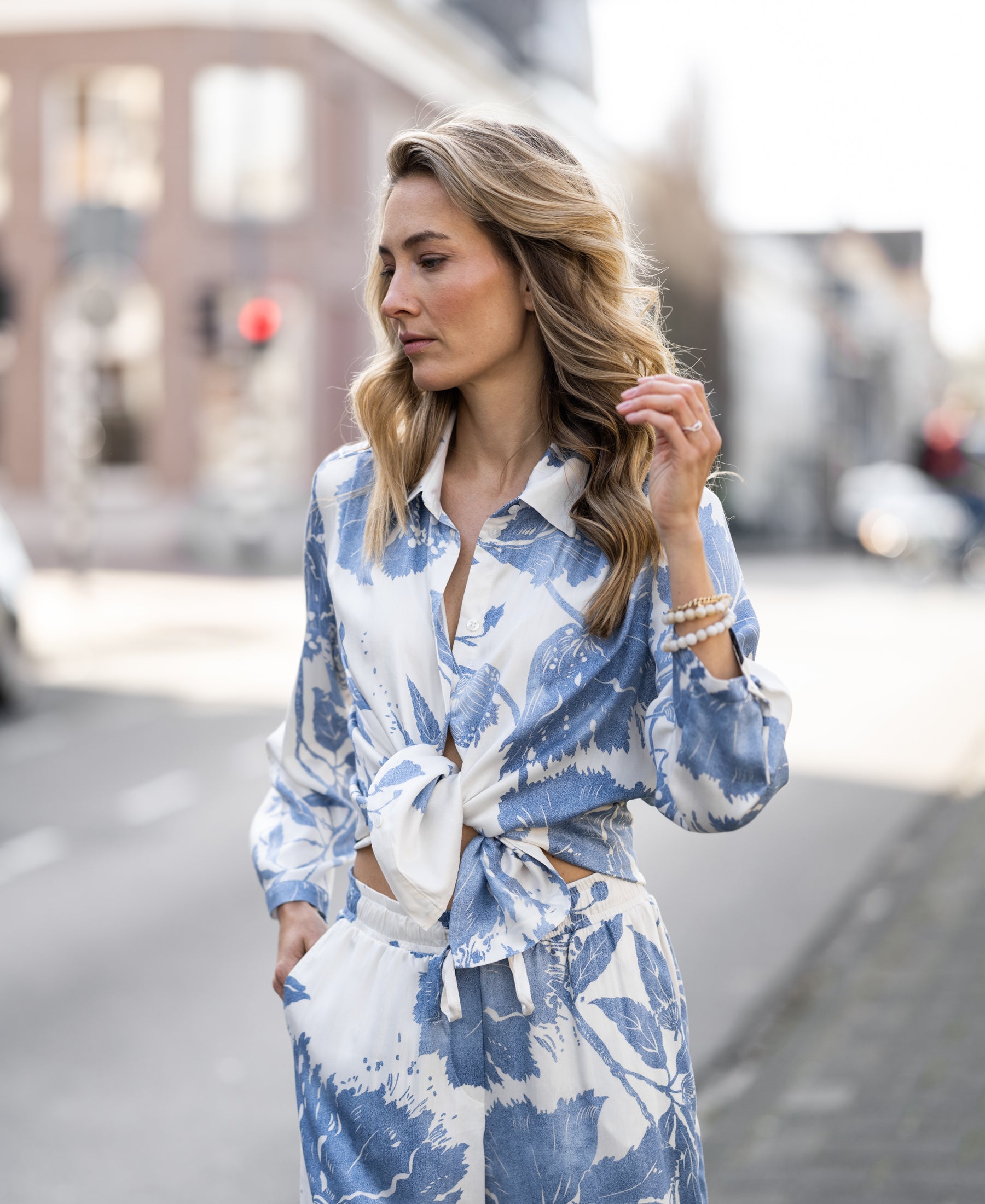 Floral print summer trousers by PLEIN PUBLIQUE, style LA JILDOU, shown on a city street.