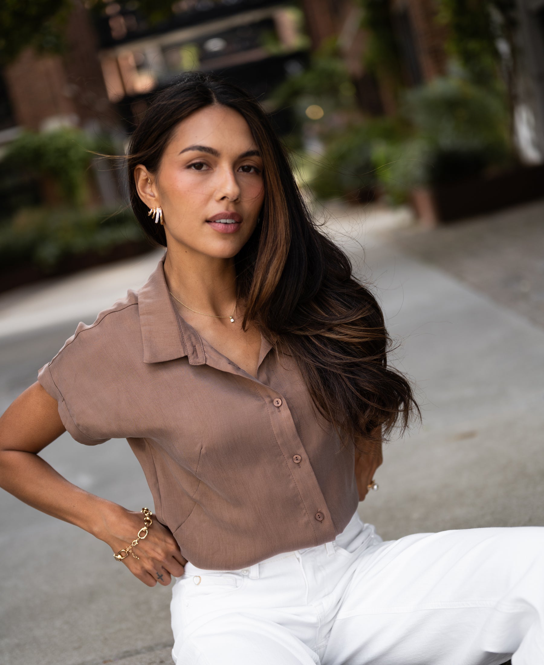Woman outdoors wearing a mocha brown cupro blouse.