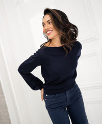 Navy blue LA MUSE boat-neck sweater by PLEIN PUBLIQUE shown against a bright, white-walled background.