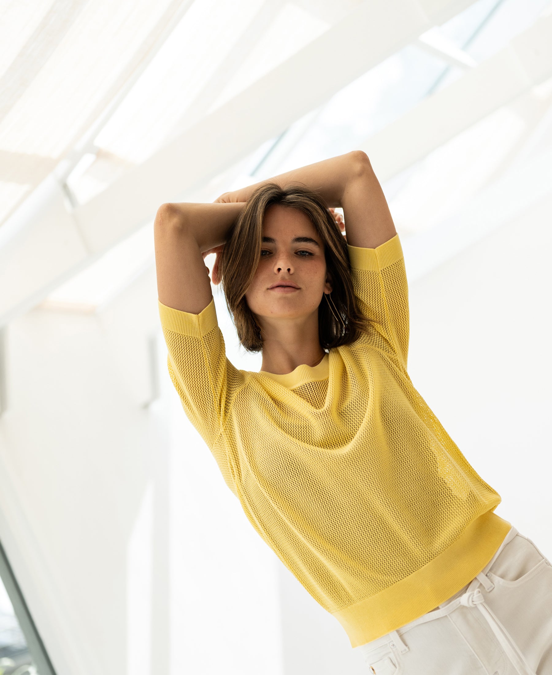 Mesh sweater LE NANCY with silk in light yellow by PLEIN PUBLIQUE, shown indoors in bright light.