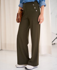 Person wearing dark olive green PLEIN PUBLIQUE LA NOAN Deluxe travel pants.