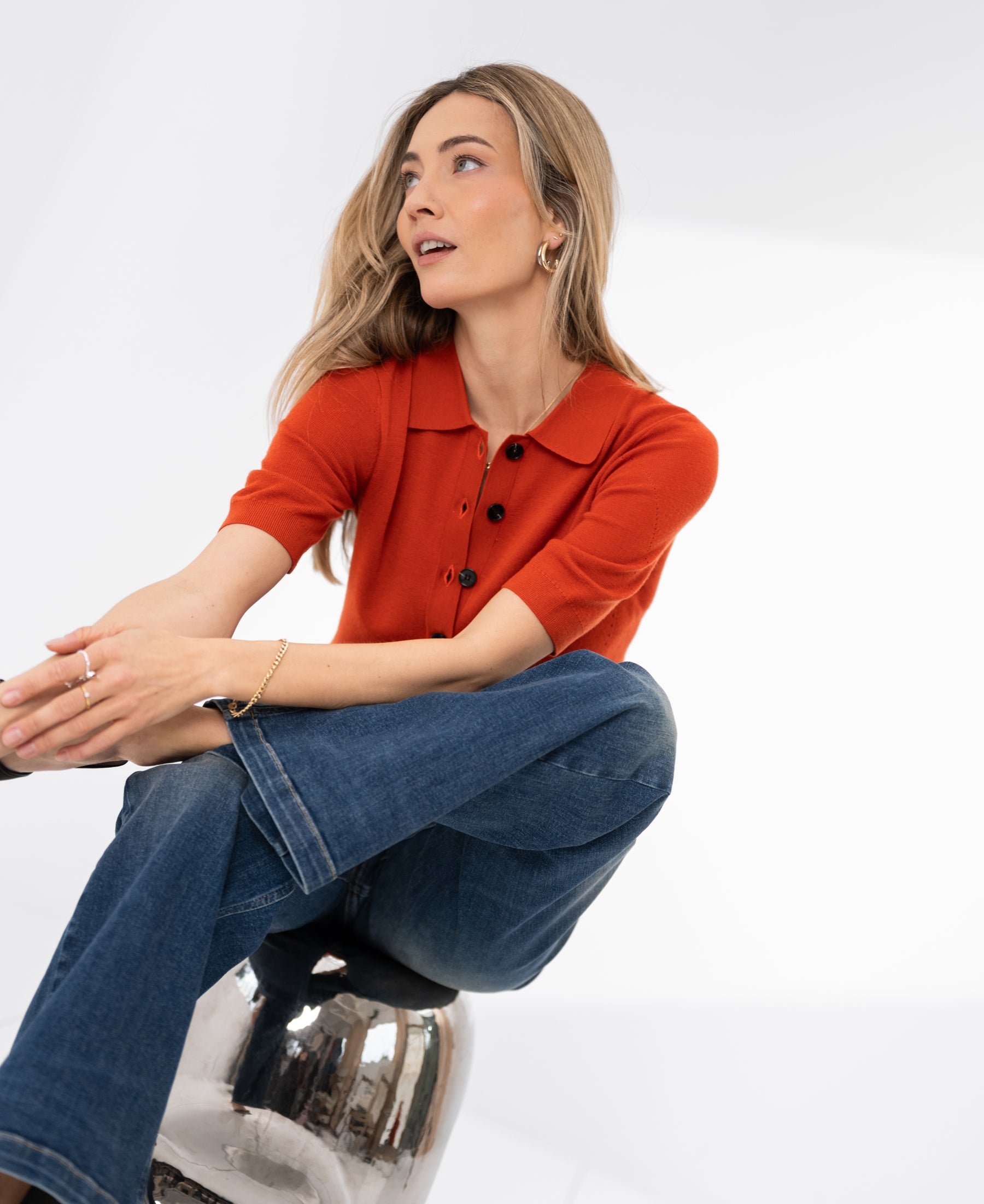 Cayenne red merino wool polo shirt by PLEIN PUBLIQUE, shown worn by a woman.