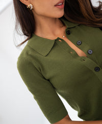 Woman wearing merino wool polo in olive green, side view.