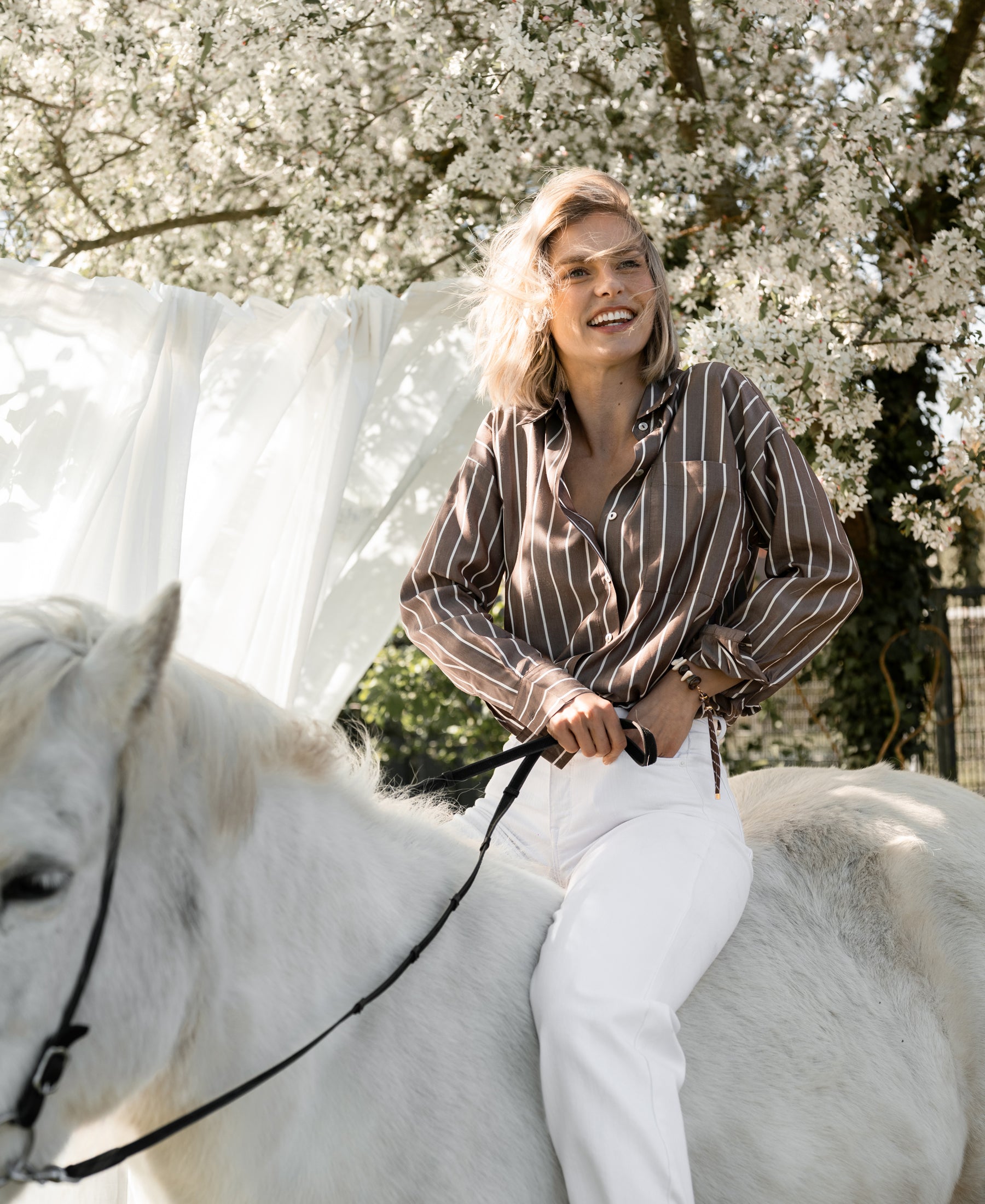PLEIN PUBLIQUE Tencel blouse in brown-ivory, shown outdoors near blooming trees.