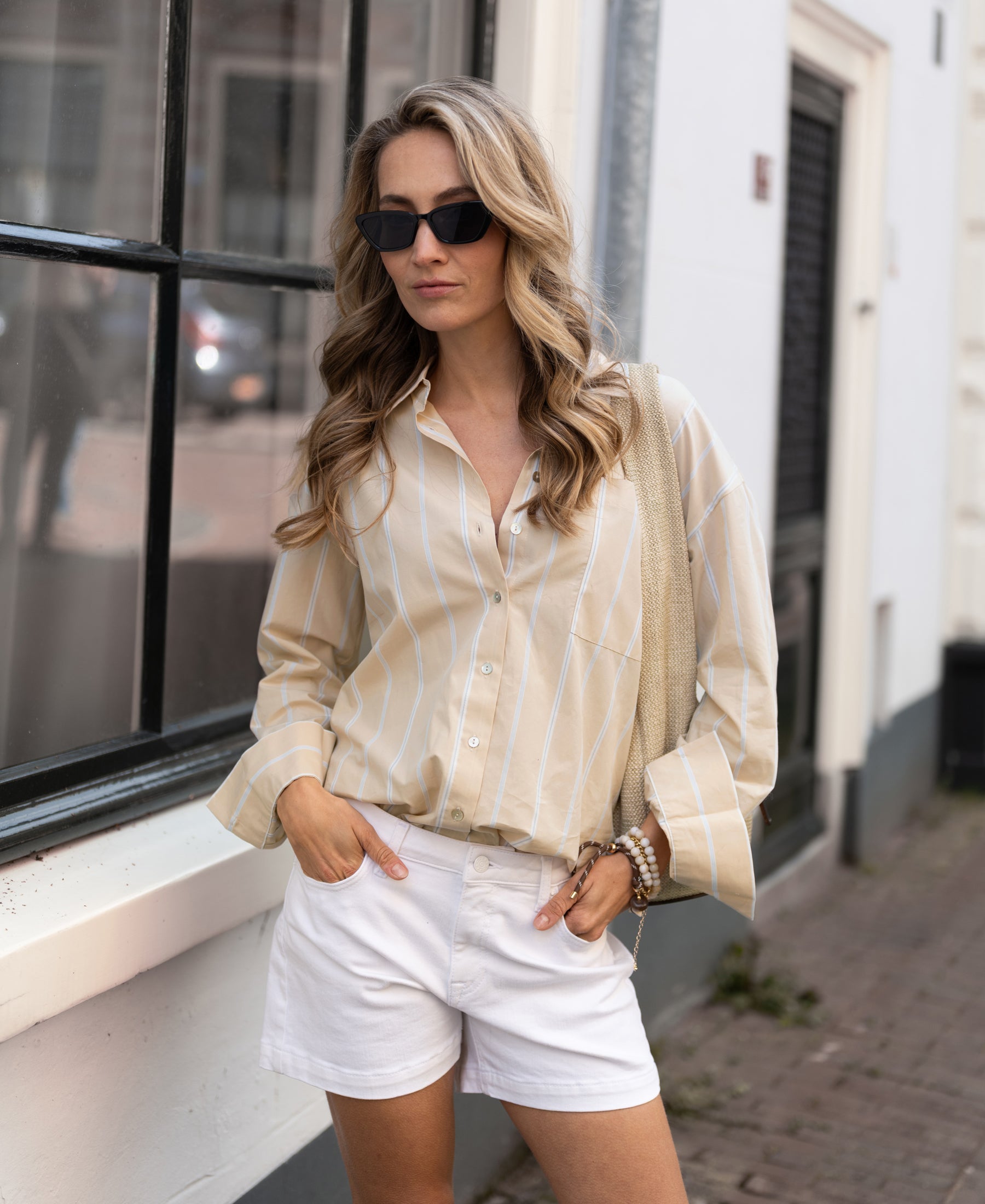 Light blue and sand striped Plein Publique LA Pascale blouse, shown from the front with hands in pockets.