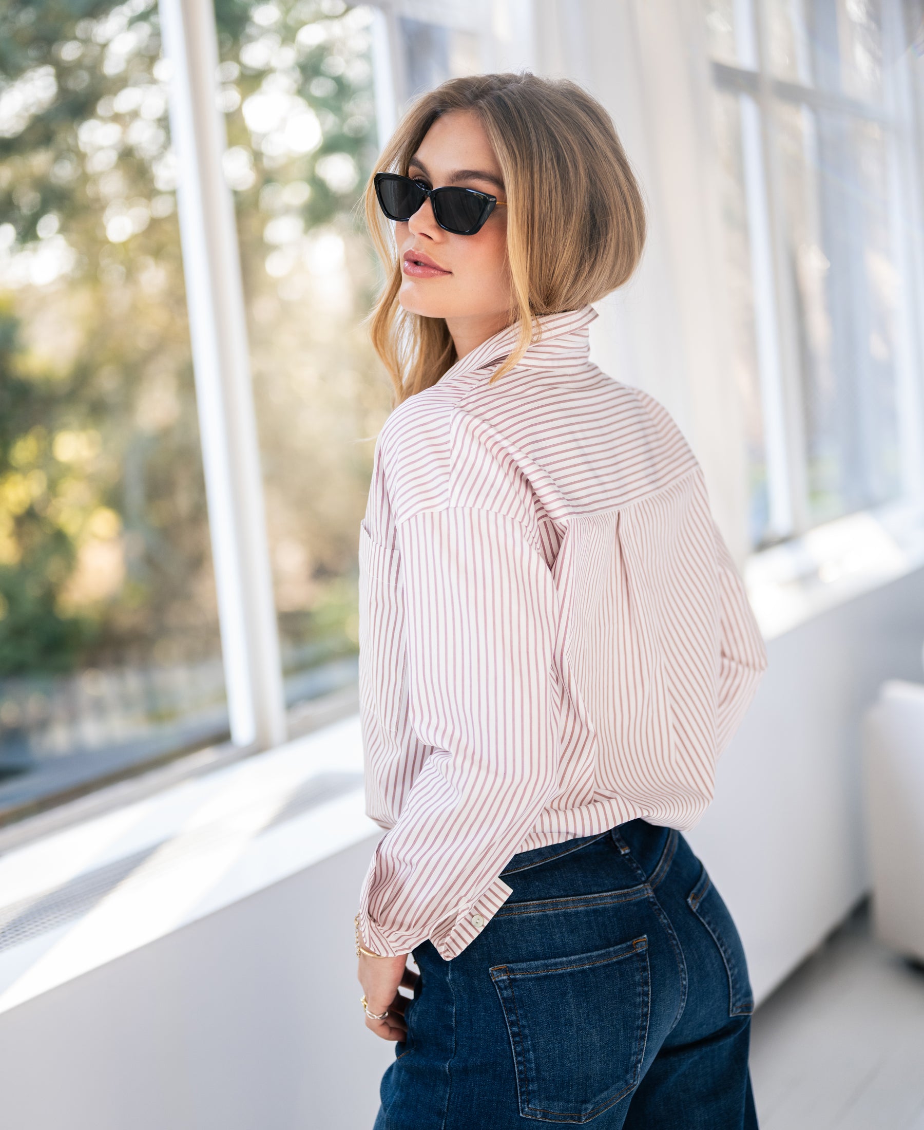 White blouse with dark red stripes, LA PASCALLE, shown from the back by a sunny window.
