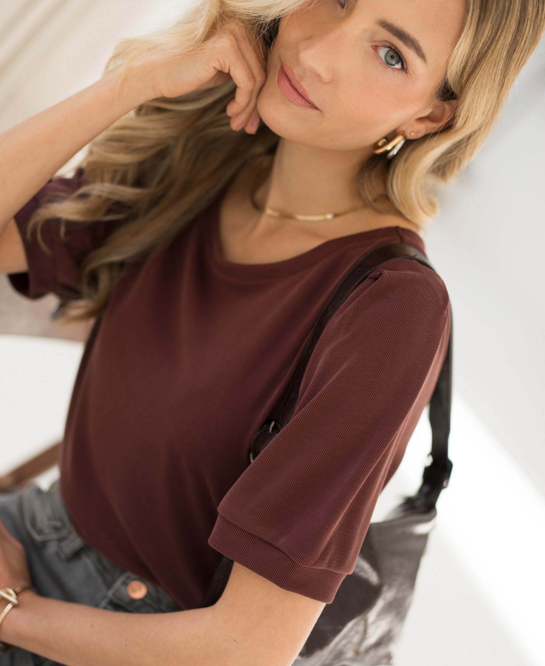 Woman wearing ribbed cacao-colored T-shirt, facing the camera.