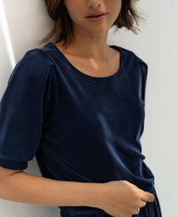 Navy ribbed T-shirt, shown from shoulders to waist against a white wall.