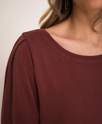 Close-up of a ribbed henna-colored T-shirt with a wide scoop neckline and collarbone showing.