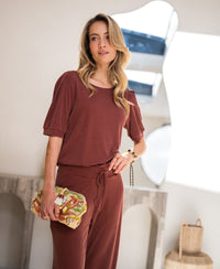 Ribbed T-shirt in henna color, shown indoors under soft lighting.