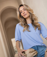 Light blue ribbed T-shirt in soft cotton, shown worn by a woman indoors.