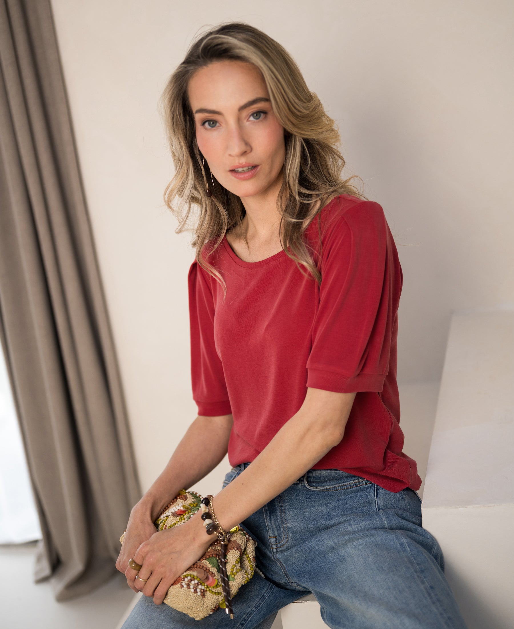 Woman wearing a red ribbed T-shirt by PLEIN PUBLIQUE.