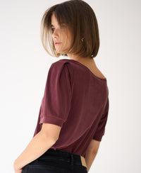 Woman wearing a wine red PLEIN PUBLIQUE ribbed T-shirt LA PHILEINE against a white background.