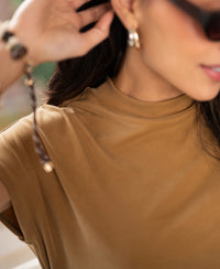 Woman wearing yellow ribbed crew neck top.
