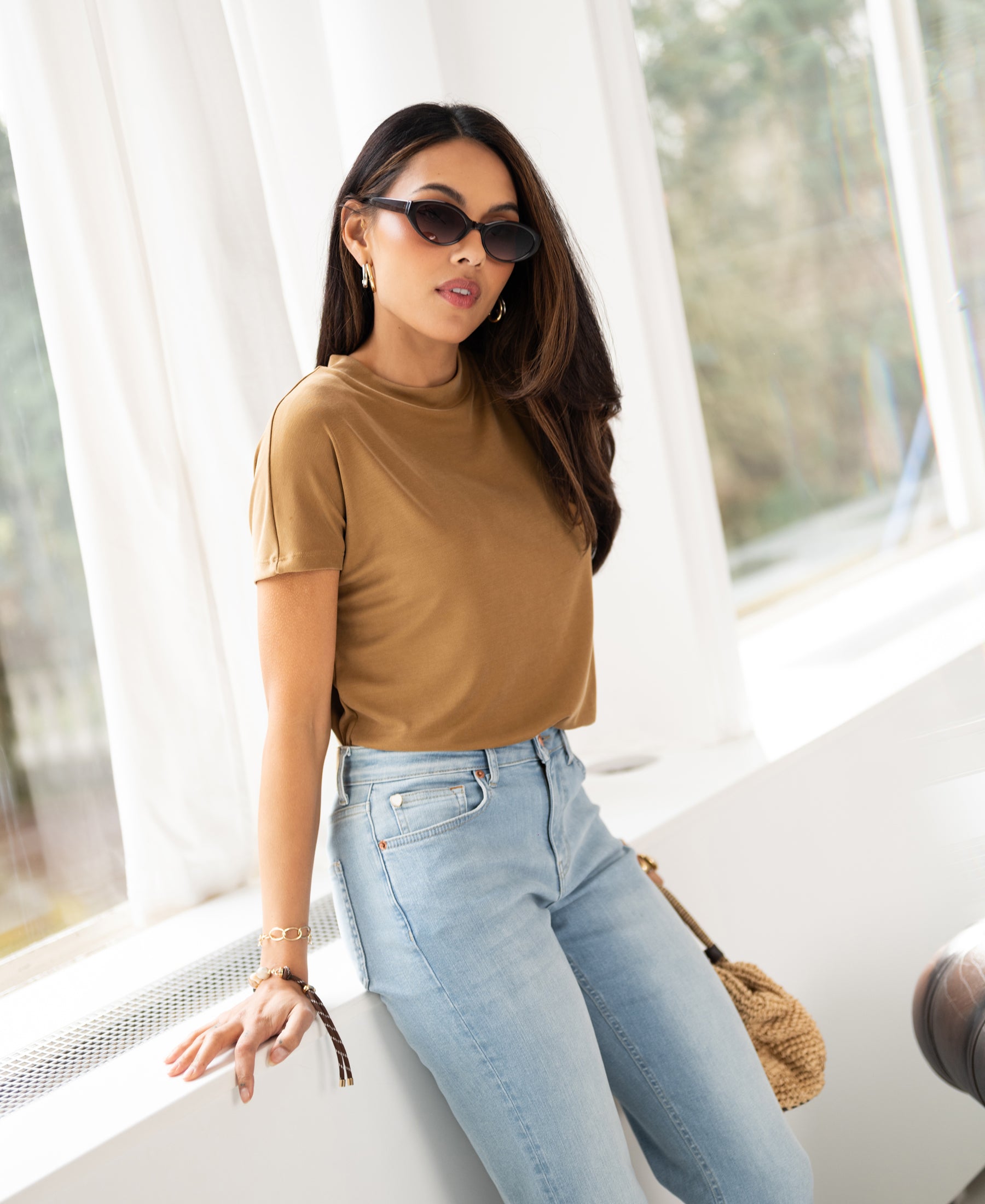Yellow ribbed collared top by Plein Publique, LA PIERRE style, shown on a woman standing by a window.