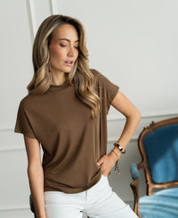 Woman wearing a ribbed tobacco brown LA PIERRE collared top by PLEIN PUBLIQUE.