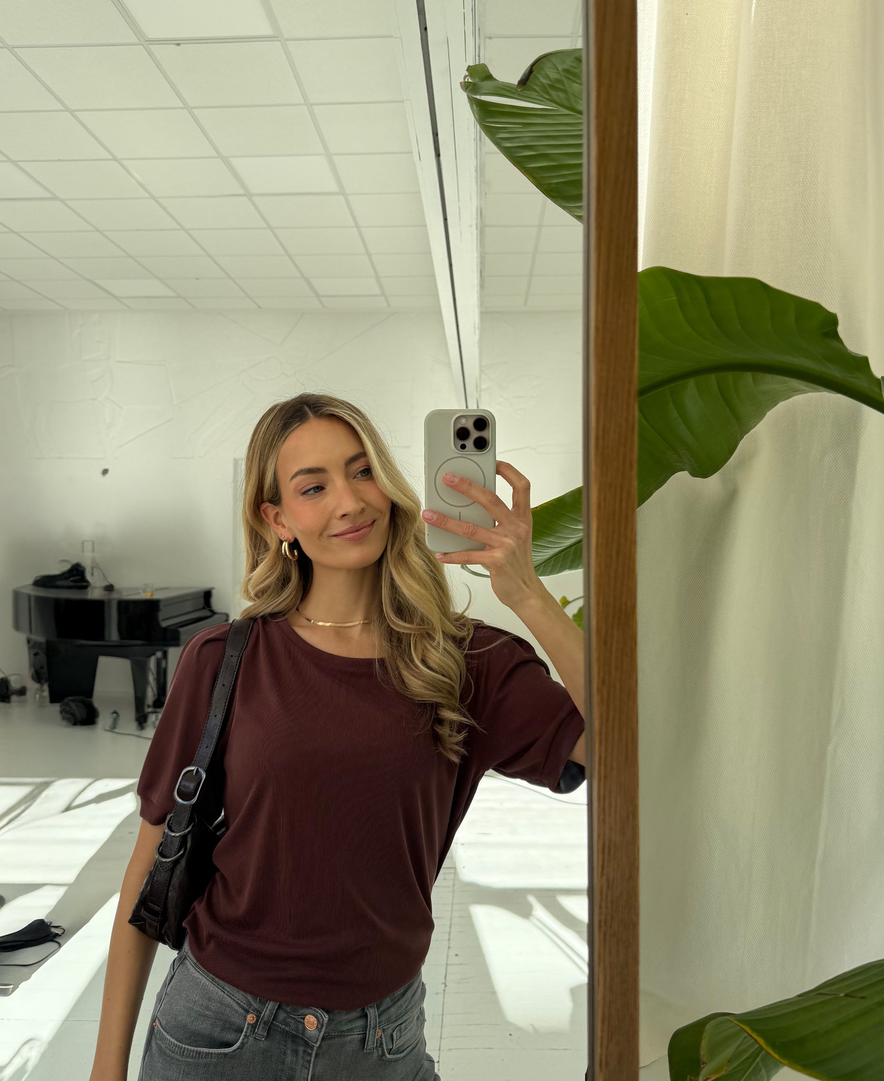 Woman wearing a ribbed cacao-colored T-shirt, mirror selfie, showing product fit and texture.