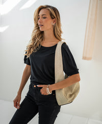 Charcoal ribbed T-shirt made of cotton, shown worn by a woman with long blonde hair in a bright room.