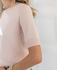 Shoulder-to-waist view of a woman wearing a blush pink LA REVE sweater.