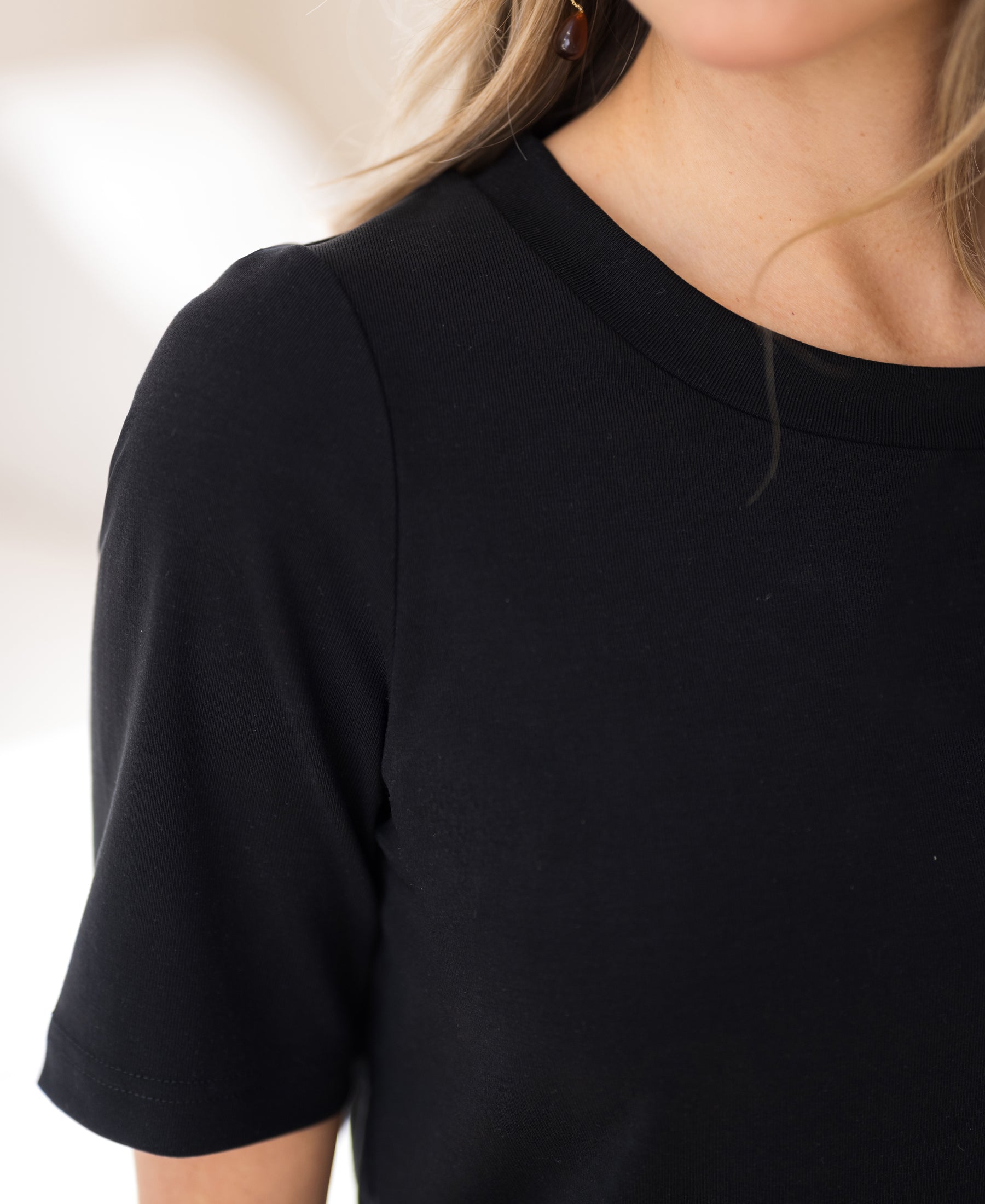 Close-up of a black PLEIN PUBLIQUE stretch short-sleeve T-shirt, showing fabric texture and neckline.