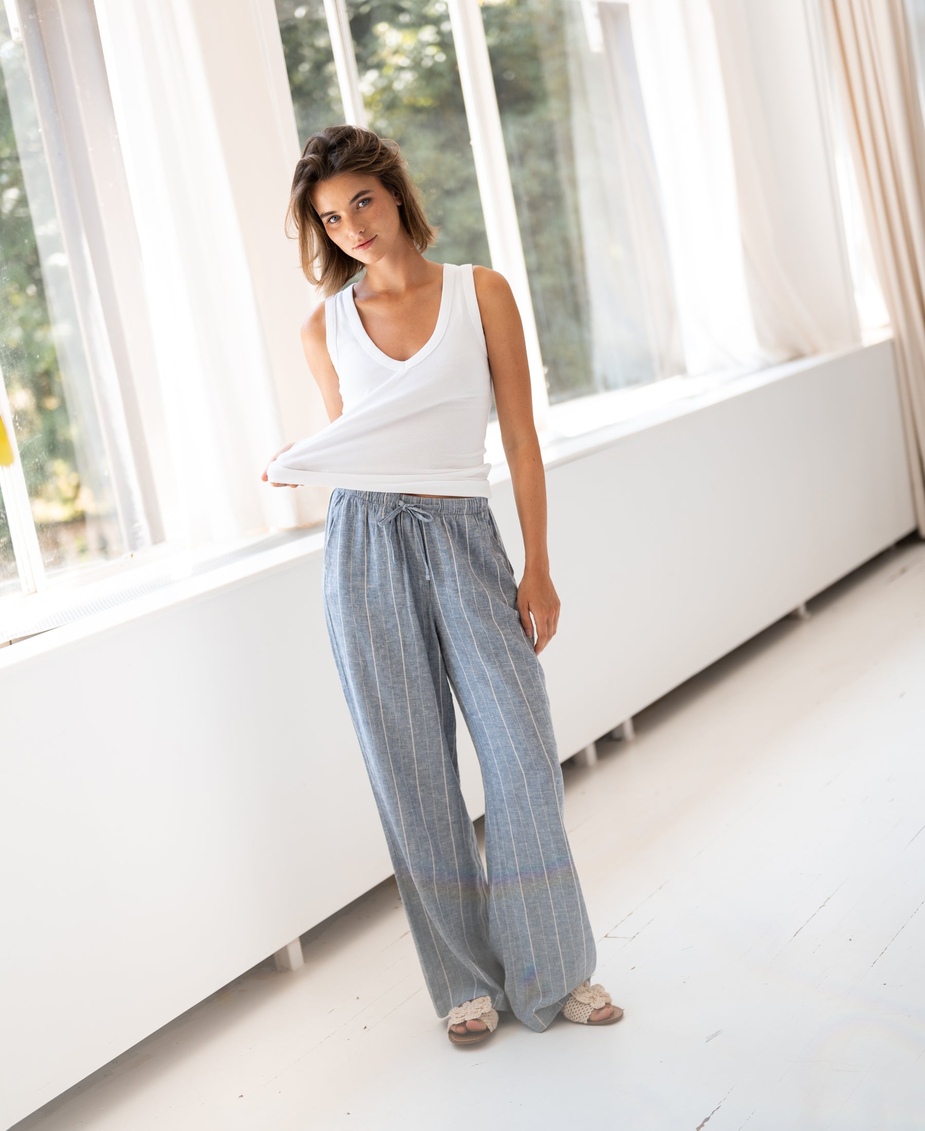 Striped linen-blend pants in jeans blue from Plein Publique, style La Seconde, shown indoors.