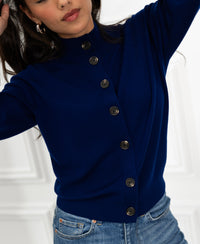 Navy merino wool turtleneck vest by PLEIN PUBLIQUE LES SEIZE shown. Model poses with one arm raised.