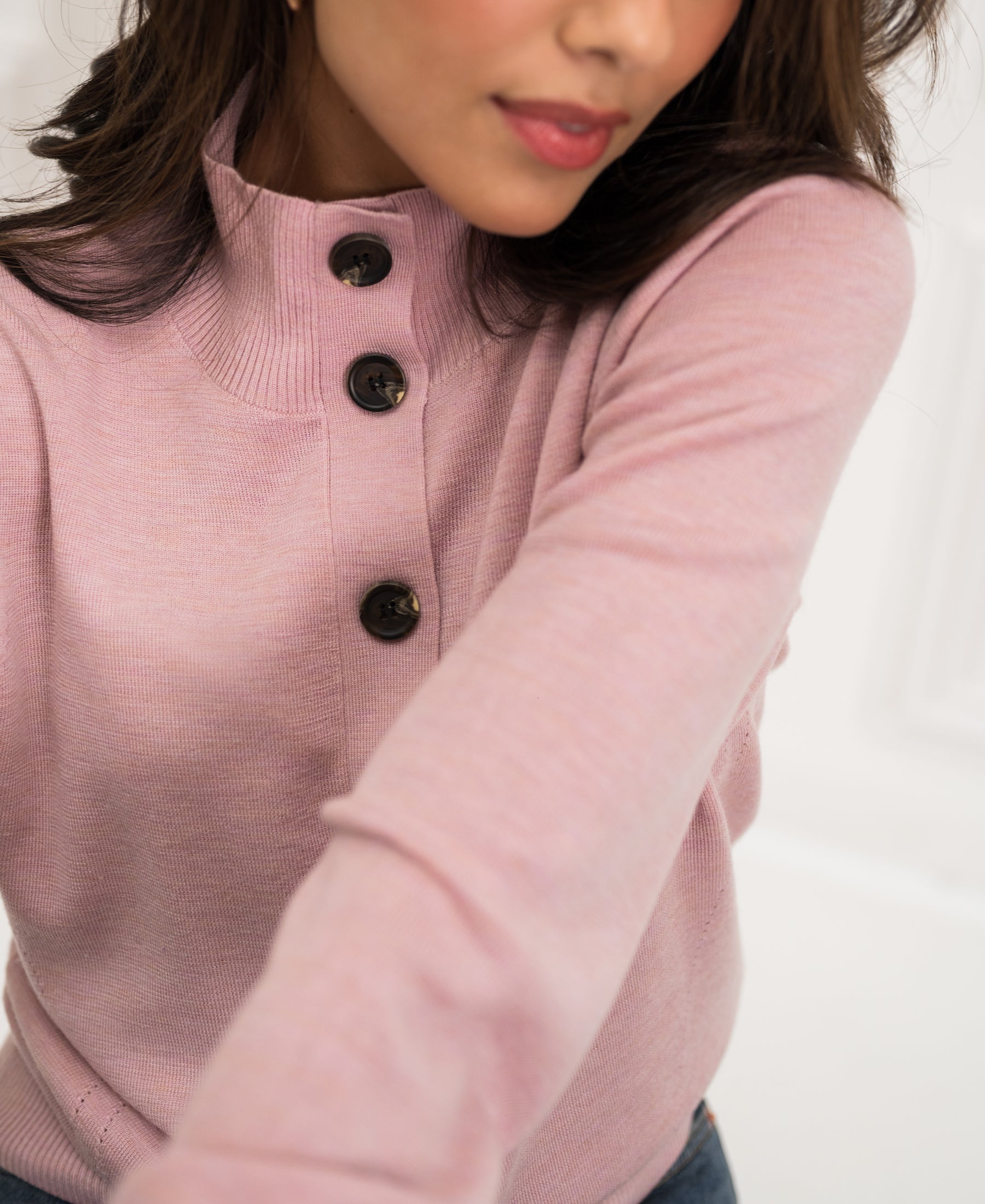 Pink merino wool turtleneck vest by PLEIN PUBLIQUE, partial view indoors.