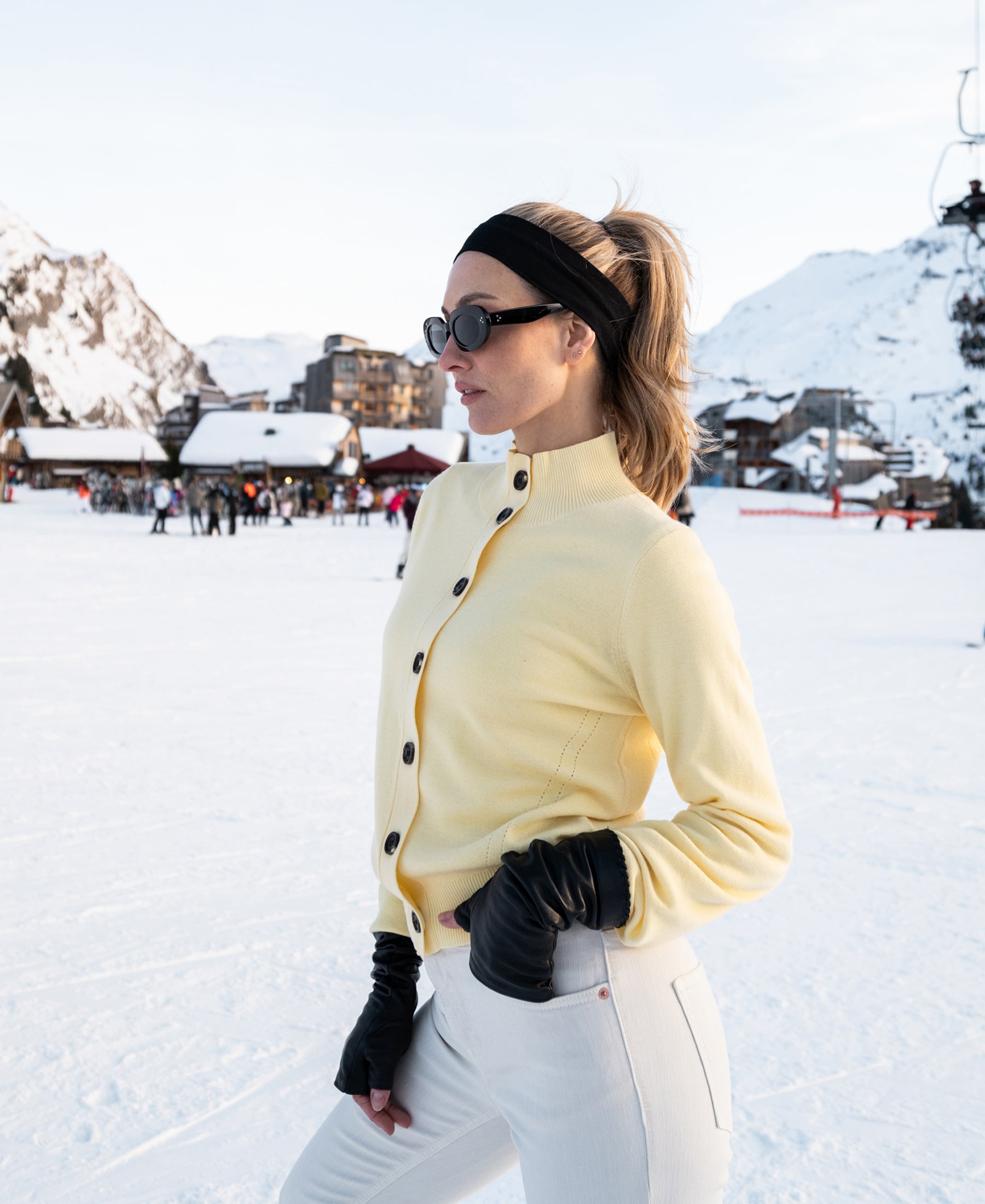 Soft yellow PLEIN PUBLIQUE merino wool turtleneck vest shown on a snowy ski slope.