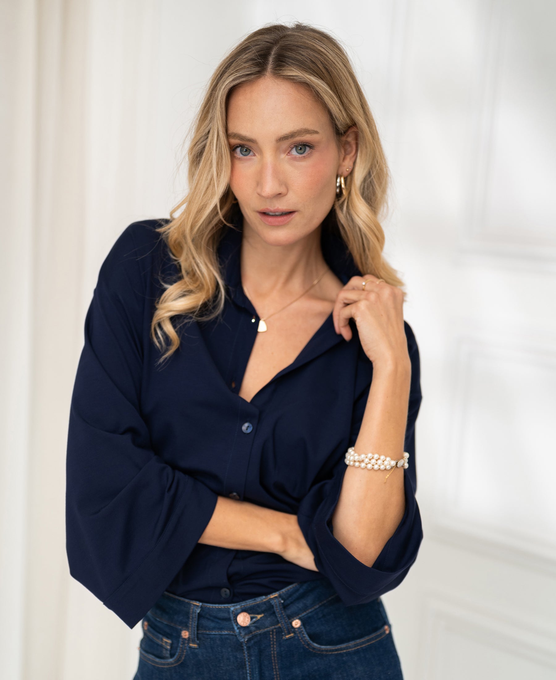 Woman wearing dark blue PLEIN PUBLIQUE LA SILVESE travel blouse, posing indoors.