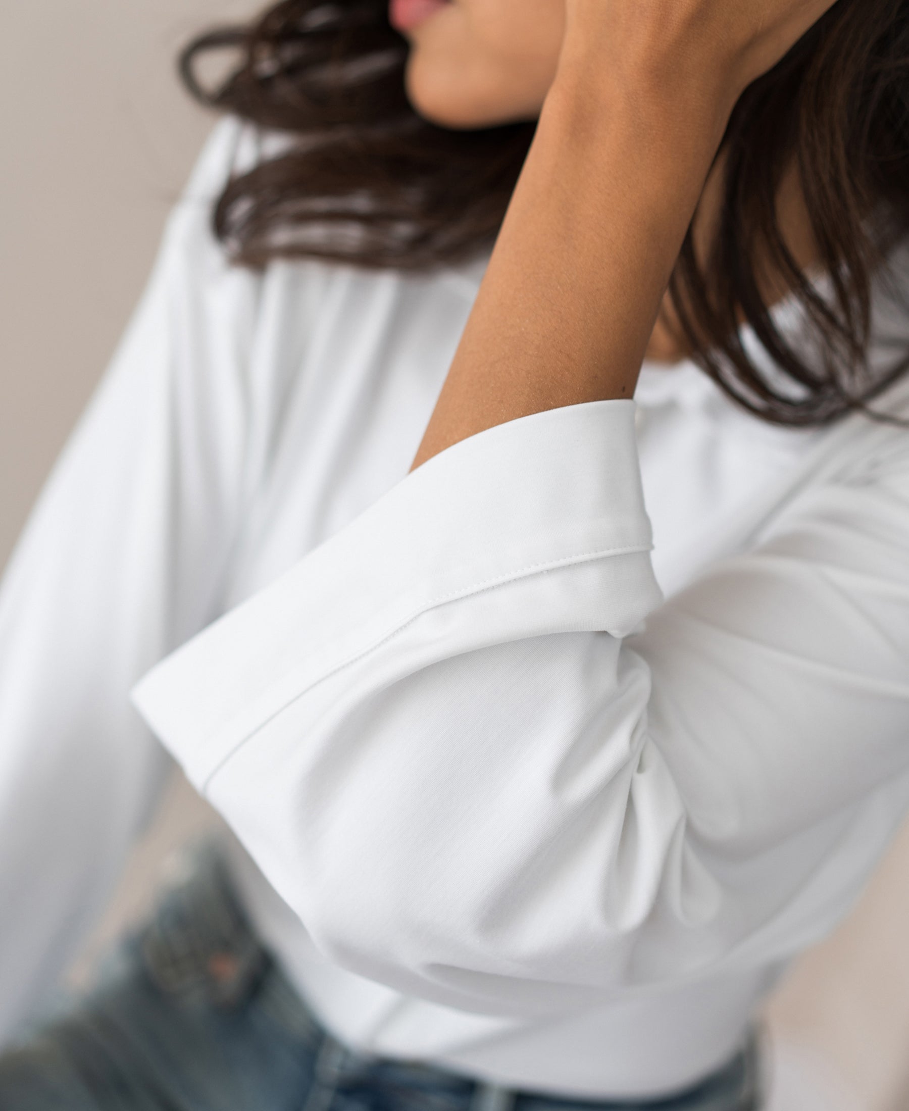 Woman wearing a white PLEIN PUBLIQUE LA SILVESE travel blouse with kimono sleeves.