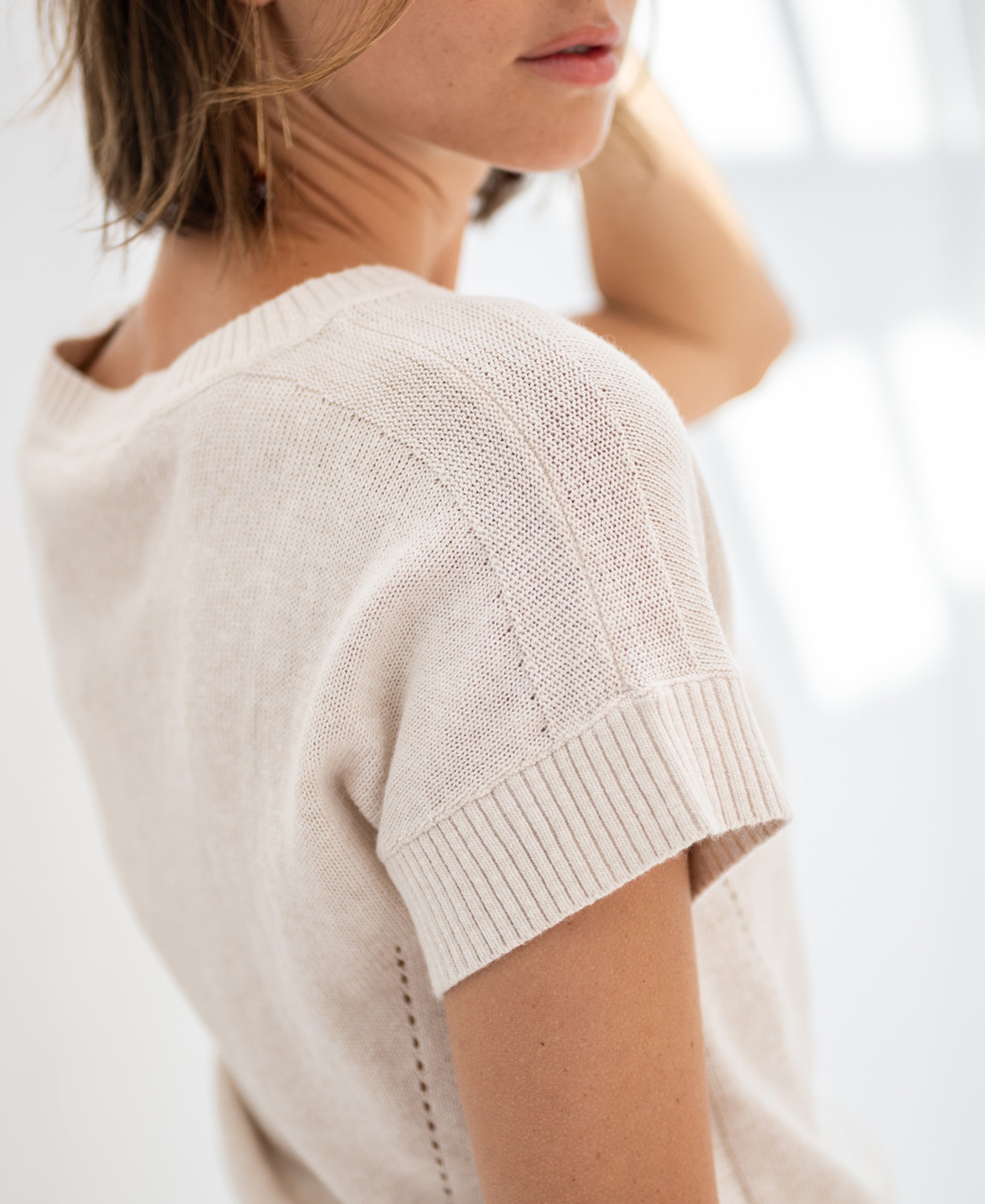 Light sand linen summer sweater, loosely knitted, shown in soft natural light.