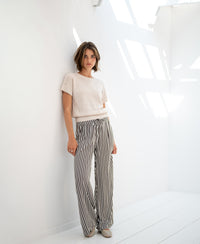 Light sand linen summer sweater LE SOLEIL shown in a sunlit white room.