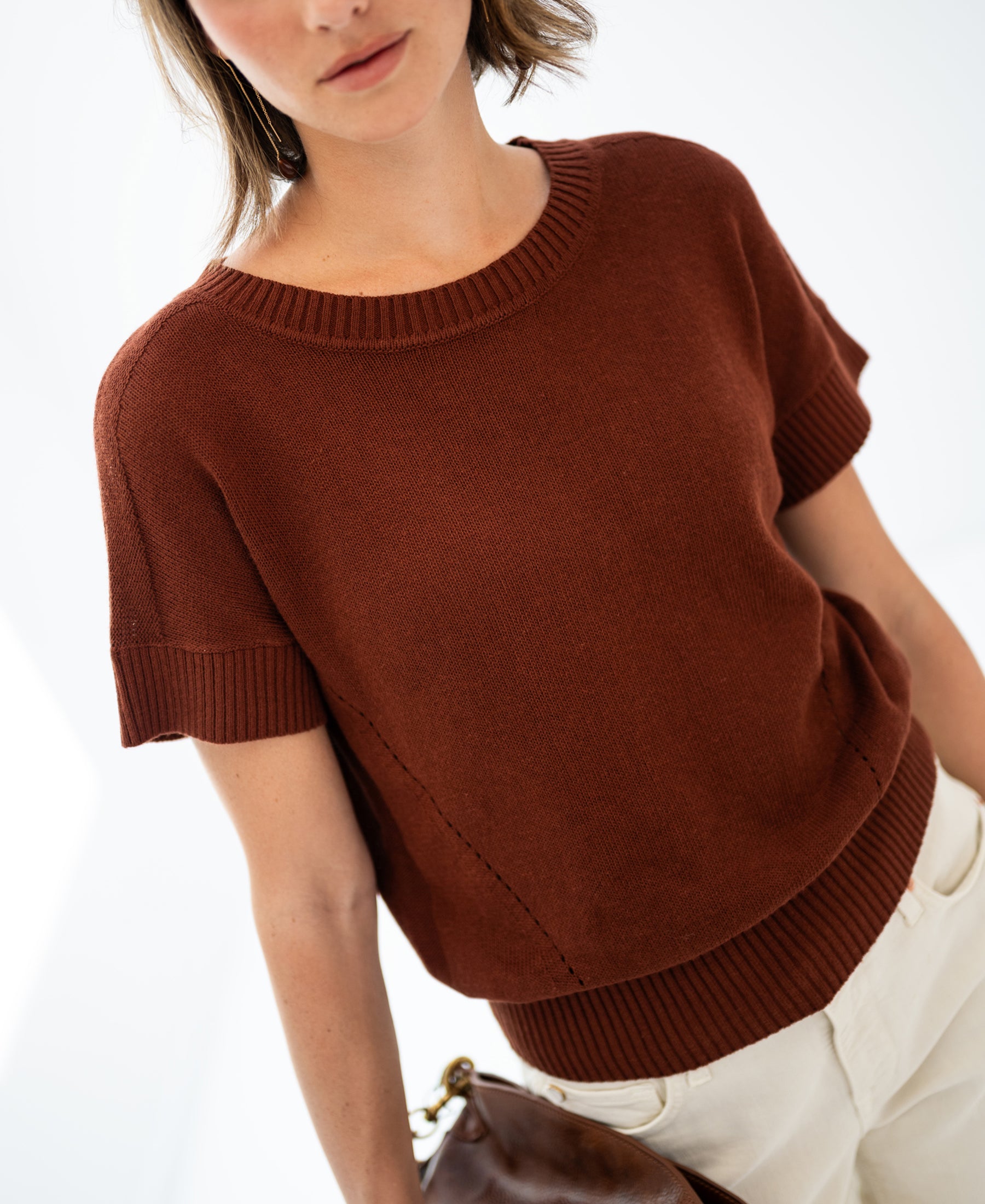 Woman wearing linen summer sweater LE SOLEIL Sierra by PLEIN PUBLIQUE, against a white background.