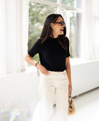 Woman indoors wearing a black PLEIN PUBLIQUE bamboo collared top.