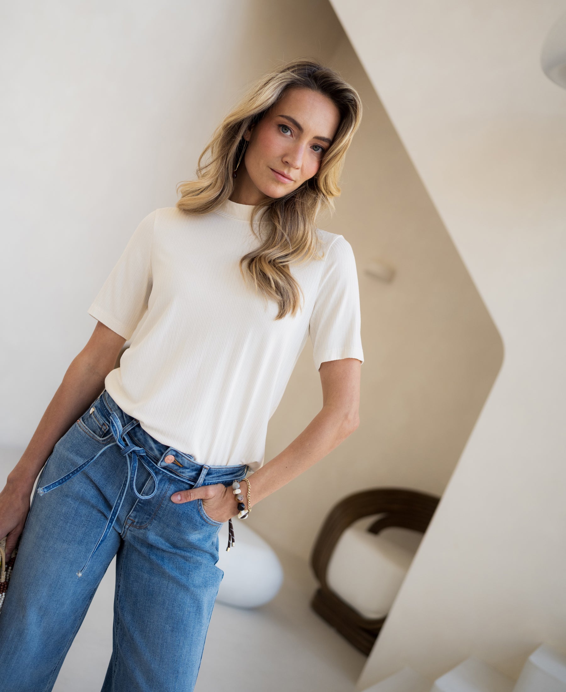Cream bamboo long-sleeved top by PLEIN PUBLIQUE, shown in a modern minimalist room.