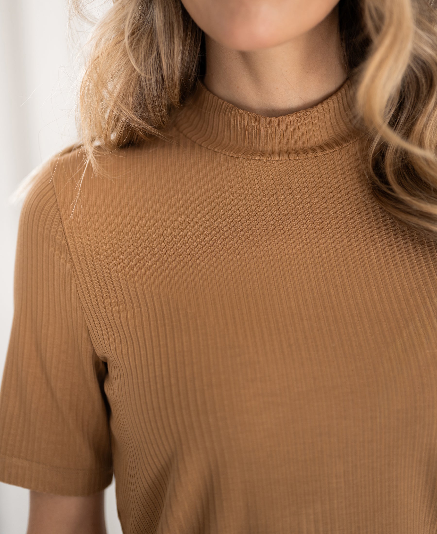 Bamboo turtleneck top in gold yellow by PLEIN PUBLIQUE, shown from shoulders to chin.