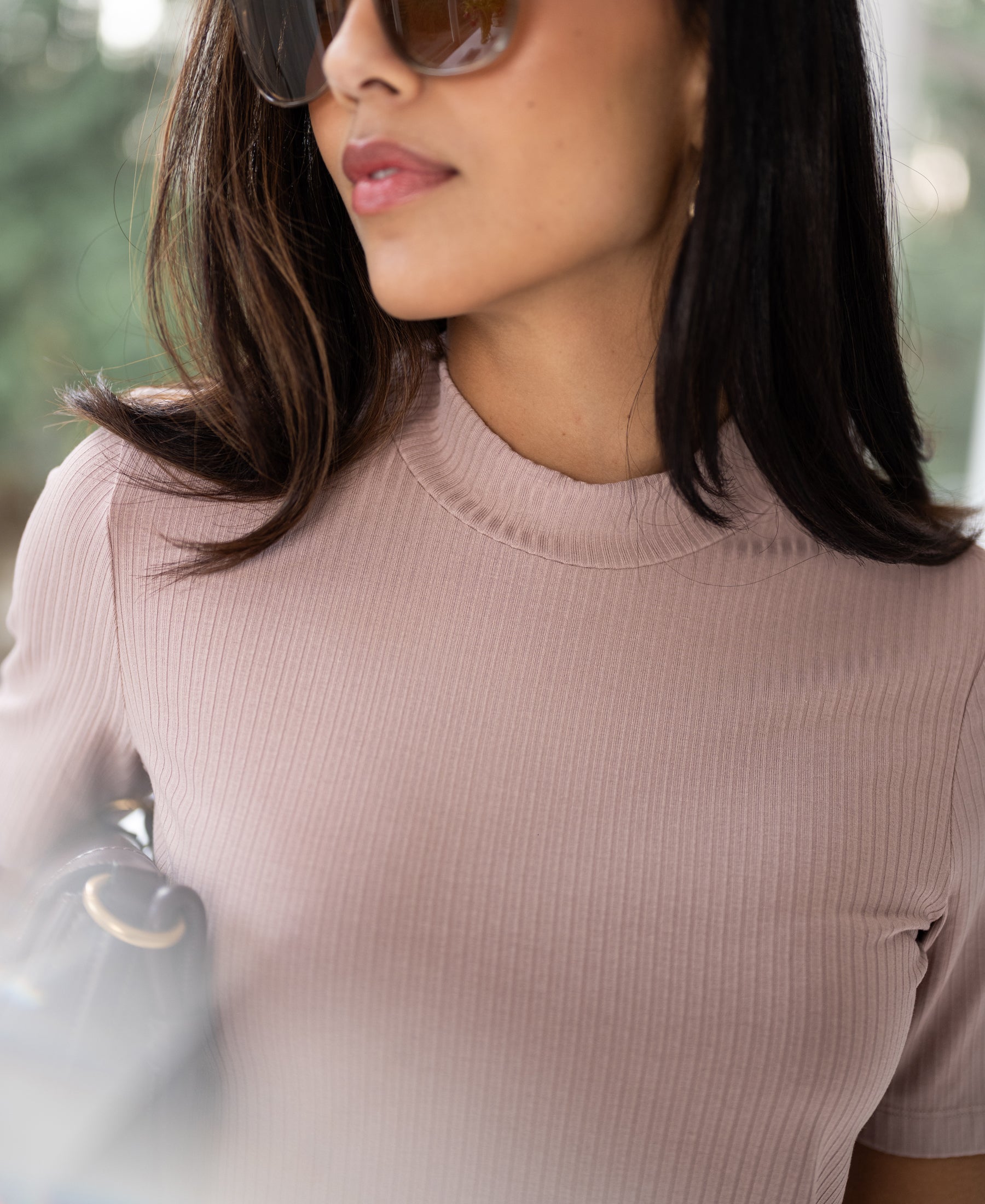 Dusty pink bamboo turtleneck top, shown outdoors.