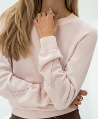 Woman wearing a blush Merino blend sweater by PLEIN PUBLIQUE.