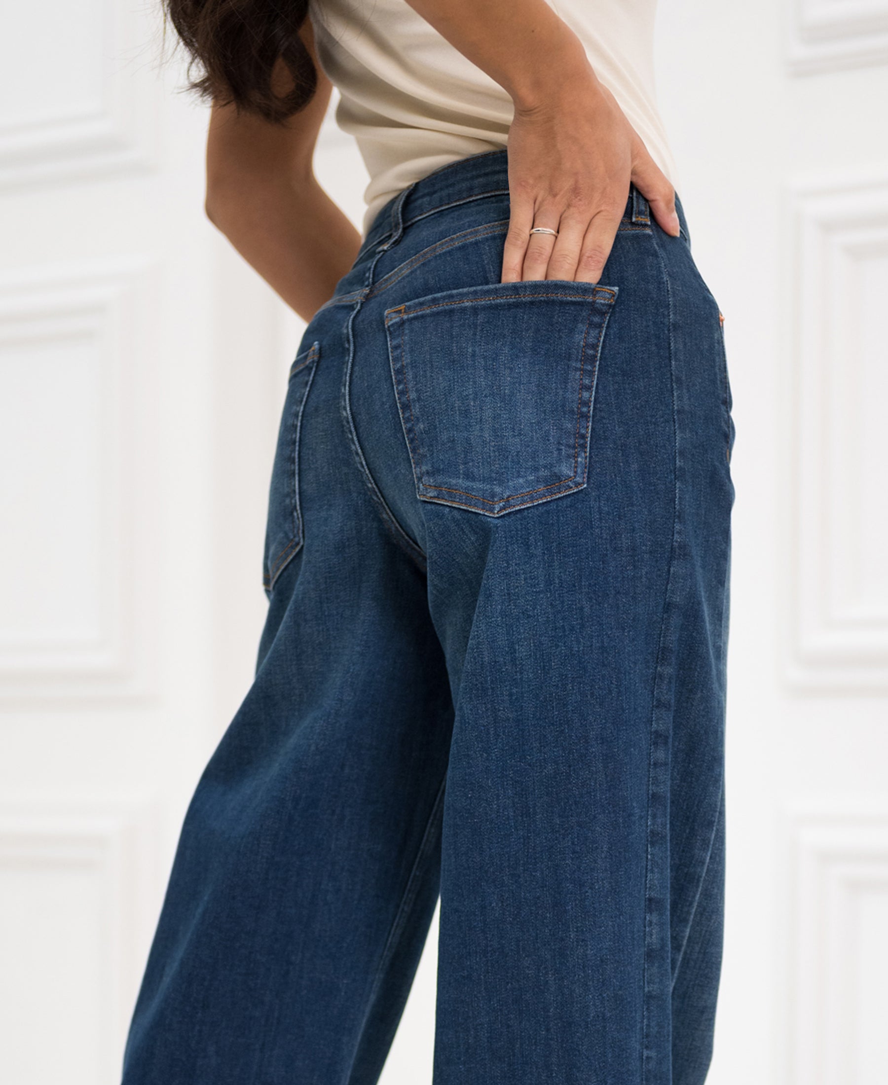 Wide leg jeans in blue heritage by PLEIN PUBLIQUE, seen from the back with a hand on the back pocket.