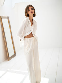 White LA TROYES blouse by PLEIN PUBLIQUE shown in a bright, minimalist room with a mirror.