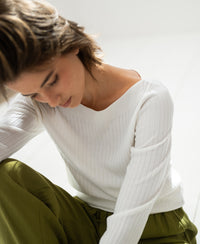 White Tencel-silk boat neck sweater by PLEIN PUBLIQUE softly illuminated by natural light.