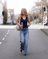 Woman wearing a Luxe & soft top LA VALE dark blue by PLEIN PUBLIQUE, standing on a city street.