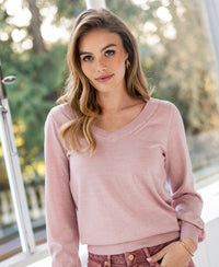 Pink PLEIN PUBLIQUE Merino wool V-neck sweater shown in sunlight.