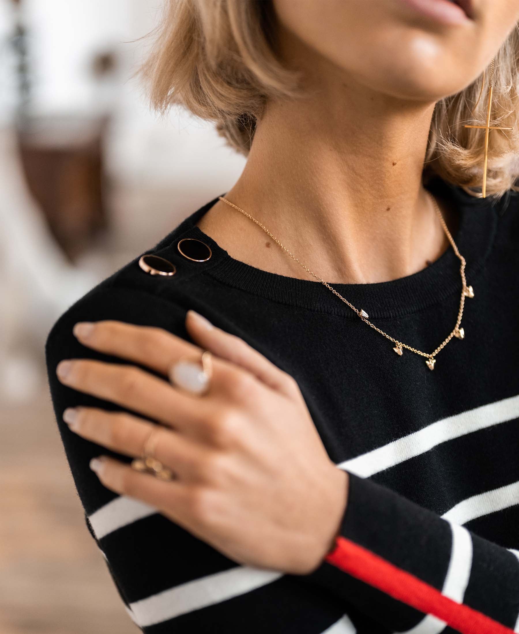 Woman wearing black and ivory PLEIN PUBLIQUE L'ELISA sweater, hand on her shoulder.