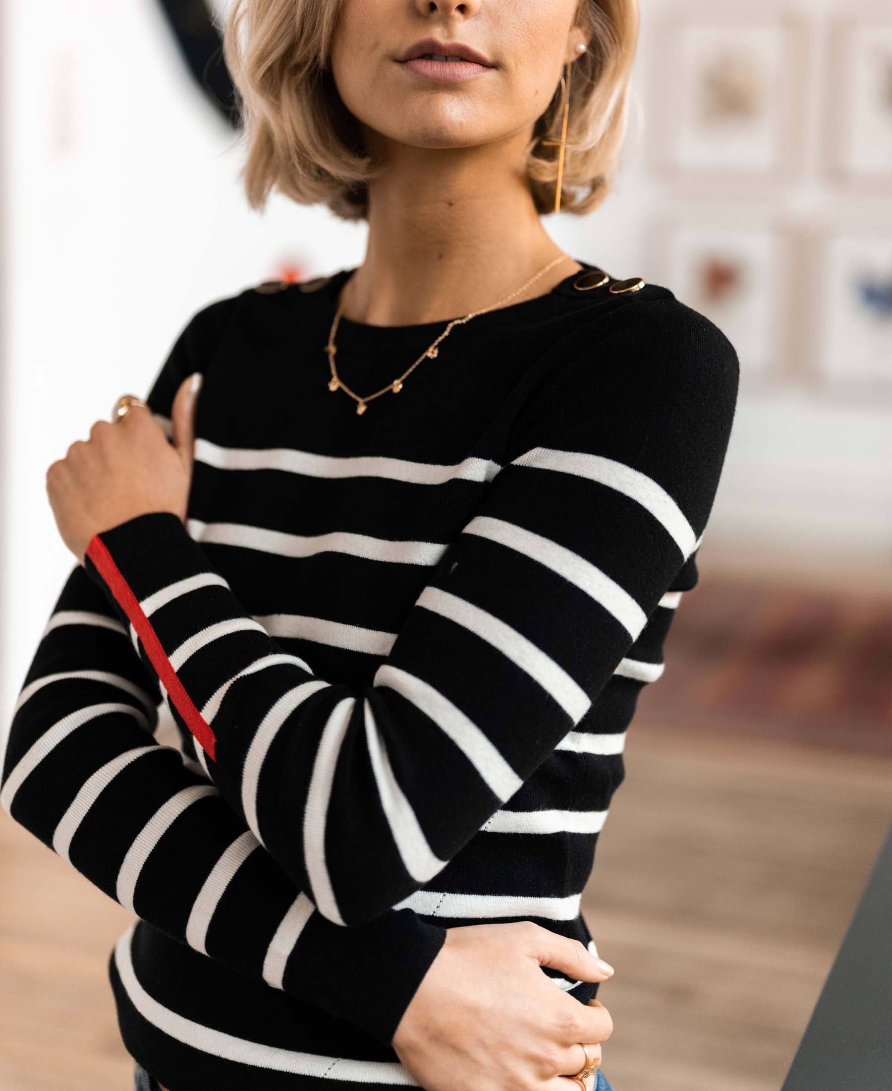 Woman wearing black and ivory PLEIN PUBLIQUE L'ELISA sweater, indoors.
